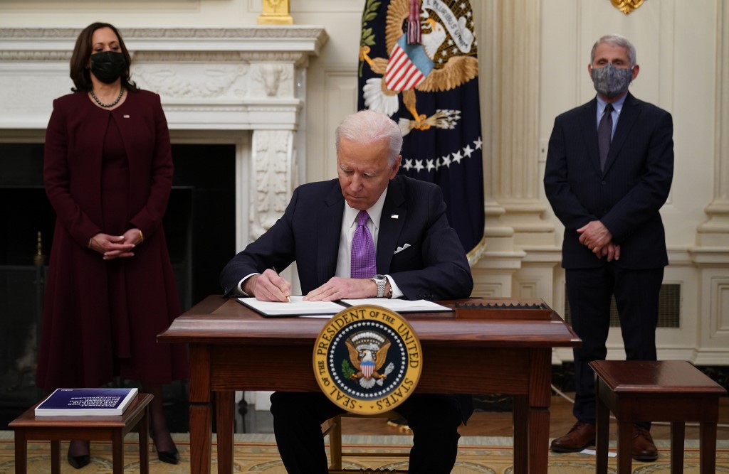 Joe Biden firma el plan contra el coronavirus. | AFP