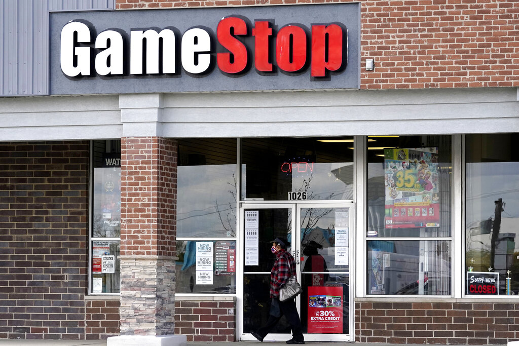 Una mujer usa una máscara facial mientras pasa frente a una tienda GameStop en Des Plaines| Foto: AP