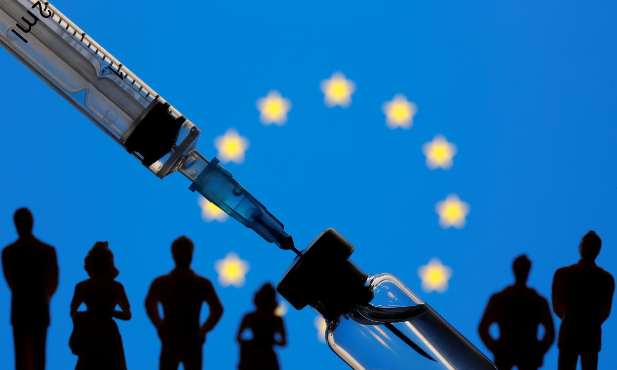 Una jeringuilla extrae líquido de un vial frente a una bandera de la UE | Reuters
