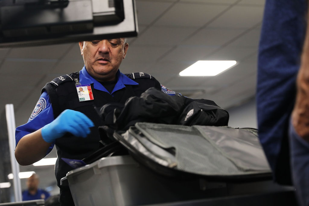 Agente de la TSA revisando equipaje de mano de un pasajero, Foto: Spencer Platt/Getty Images