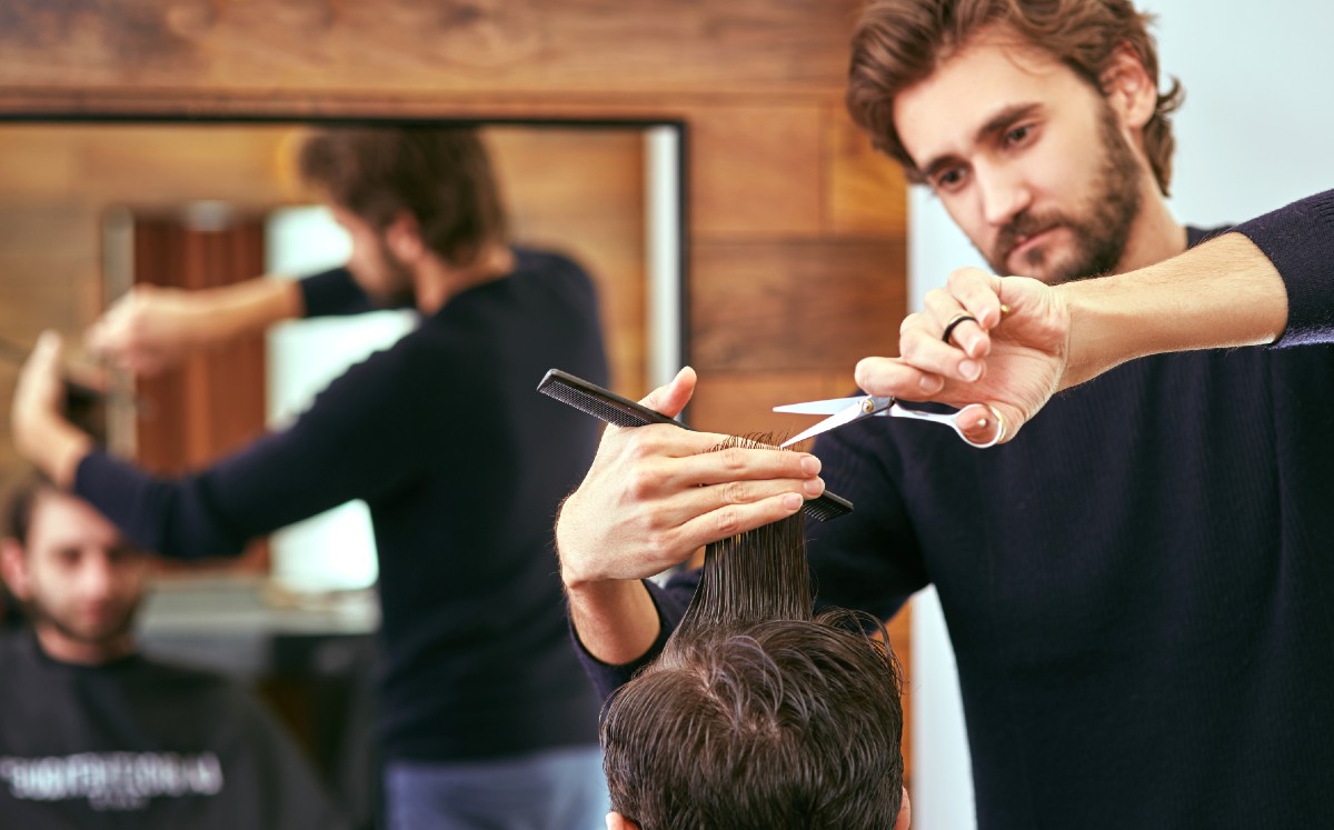 Peluquero subasta primer turno en su estética (Shutterstock).
