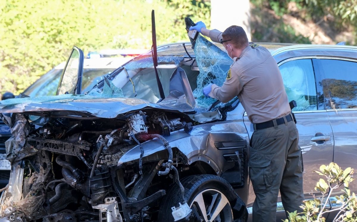 Agente policial observa el vehículo en que se accidentó el golfista Tiger Woods, en Rancho Palos Verdes, un suburbio de Los Ángeles (AP Foto/Ringo H.W
