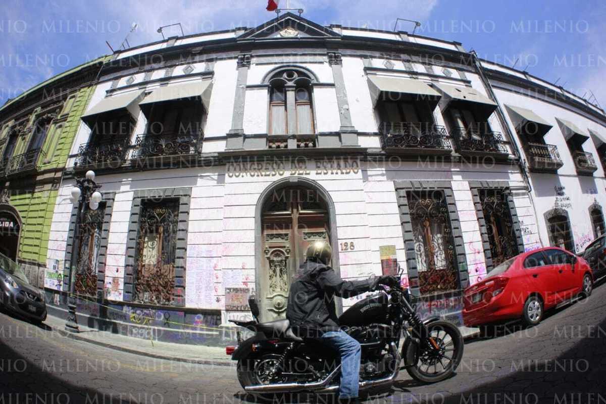 Un motociclista se detiene a ver las pintas e el Congreso del Estado. (Andrés Lobato)