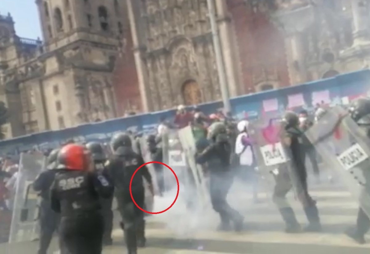 Se observa como una policía lleva la lata de gas. (Itzel Cabrera)