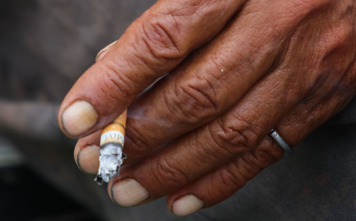 La colilla de un cigarro es sostenida por la mano de un fumador. (Cuartoscuro)
