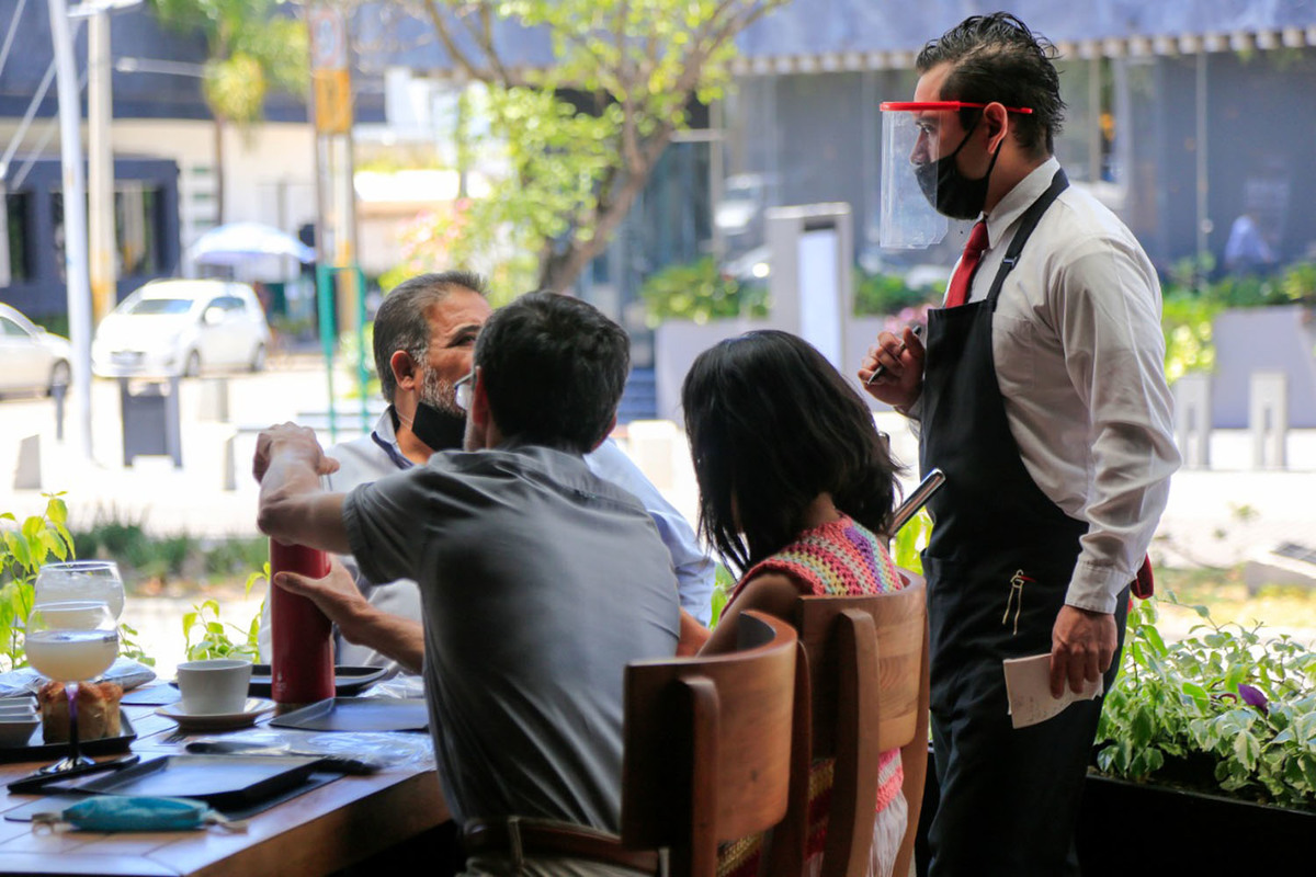 Un mesero atiende a un grupo de turistas en el corredor gastronómico de la Avenida Juárez. (Andrés Lobato)