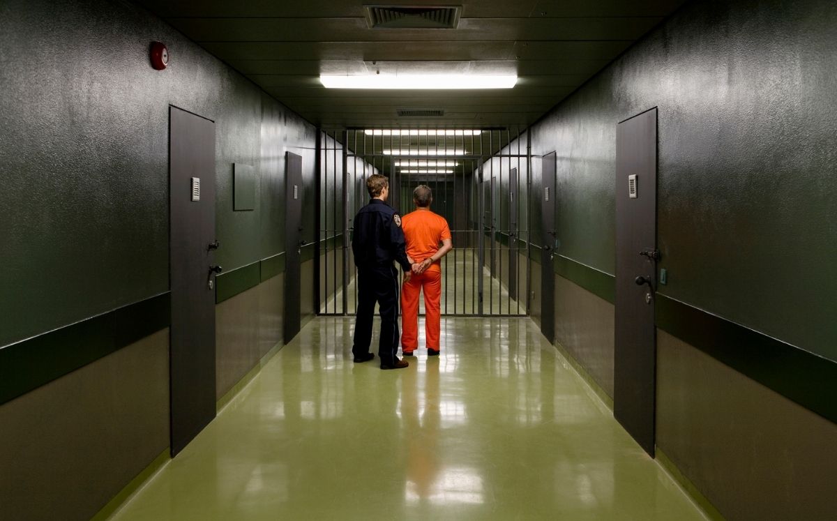 Oficial de policía escolta a preso en una cárcel. Foto:  Halfdark/ Getty Images
