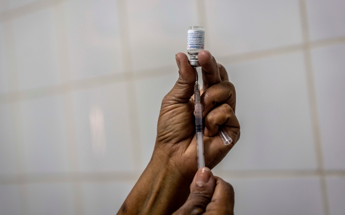 Una enfermera se prepara para inyectar a una trabajadora de la salud una dosis de la vacuna contra el covid-19. (AP)