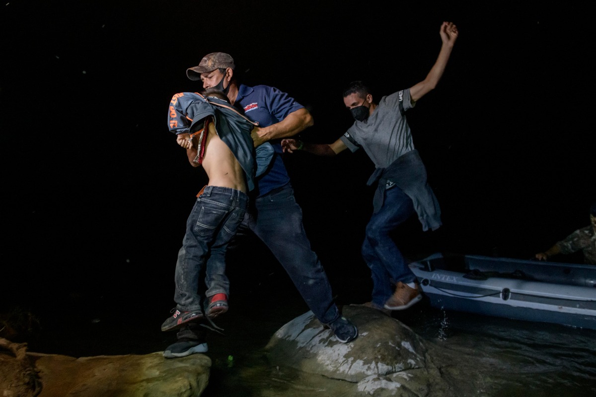Polleros bajan a niños migrantes de las lanchas. (AFP)