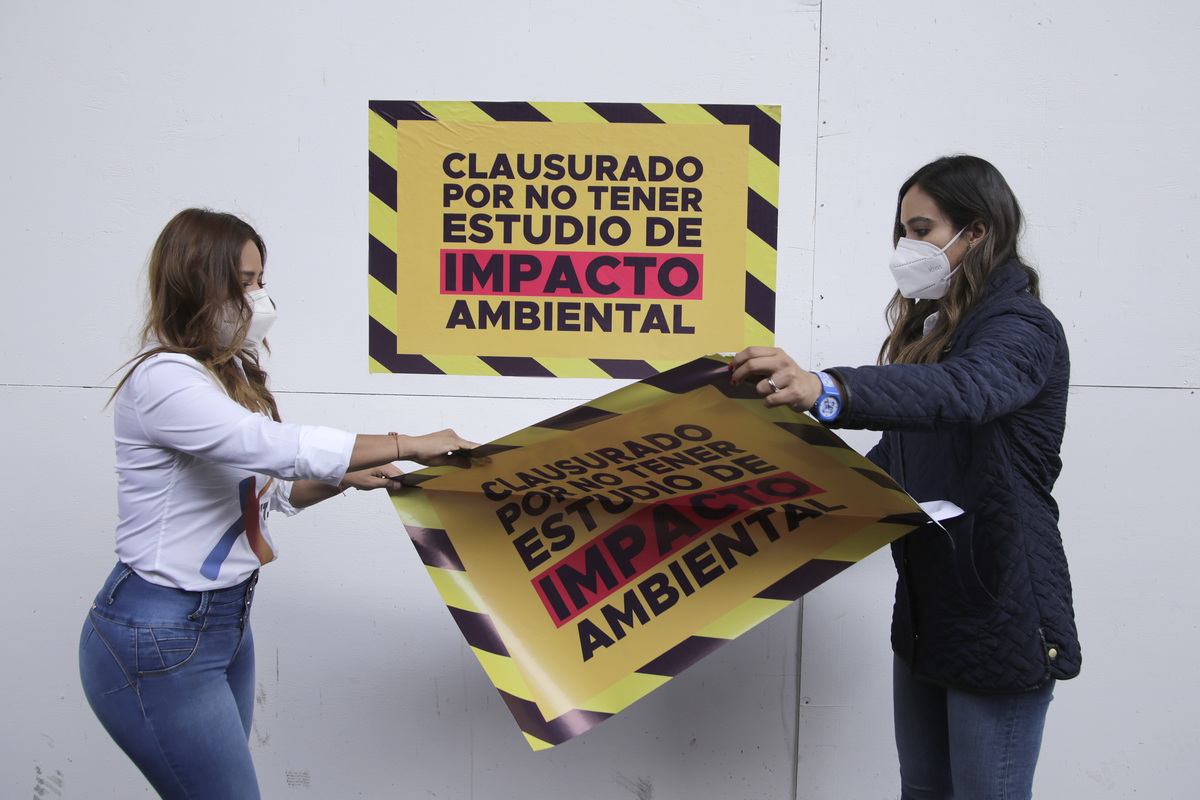 Xitlalic Ceja y Carolina Beauregard colocan letreros de clausura en las obras de rehabilitación del zócalo. (Agencia Enfoque)