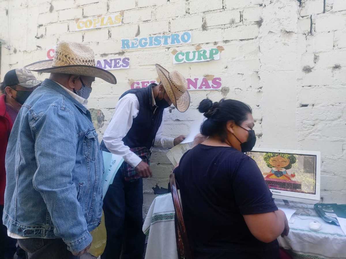 Erika y su marido, han instalado una pequeña mesa donde ayudan a realizar el trámite. (Rosario Álvarez)