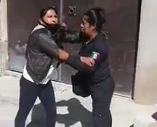 La uniformada jala a la víctima hacia la patrulla para asegurarla.