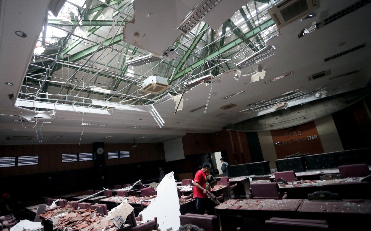 Un hombre limpia el desorden que provocó el terremoto de hoy en Indonesia. (Reuters)
