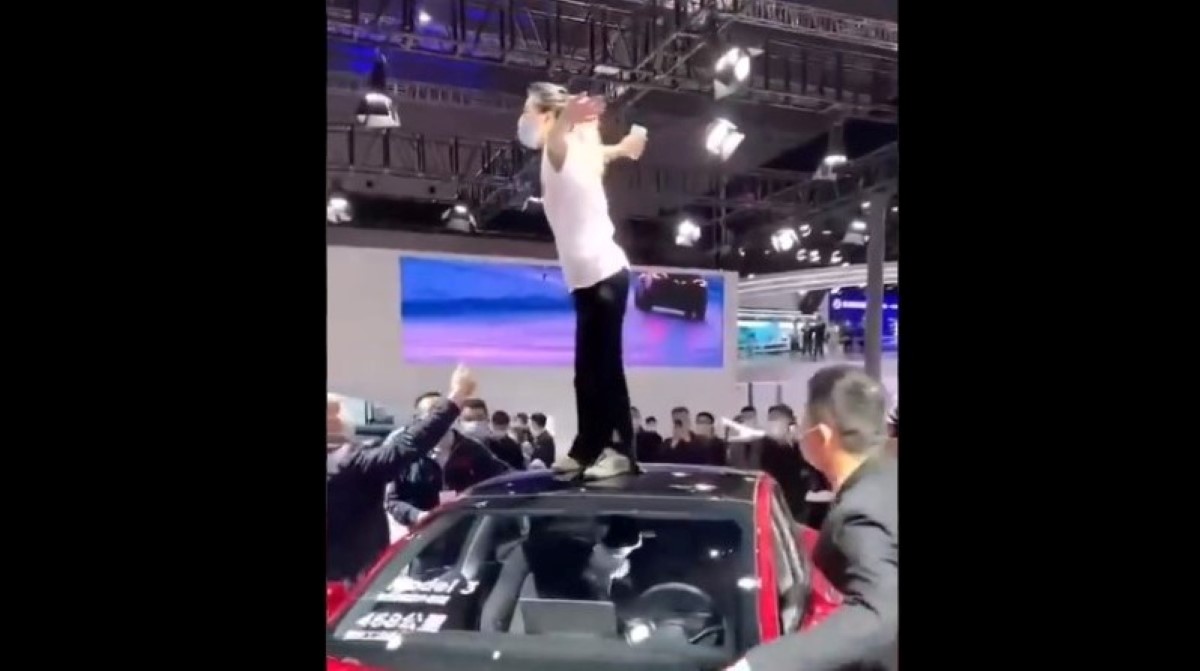 La mujer protestó encima del auto en el Autoshow de Shanghai. | Twitter @SinoAutoInsight
