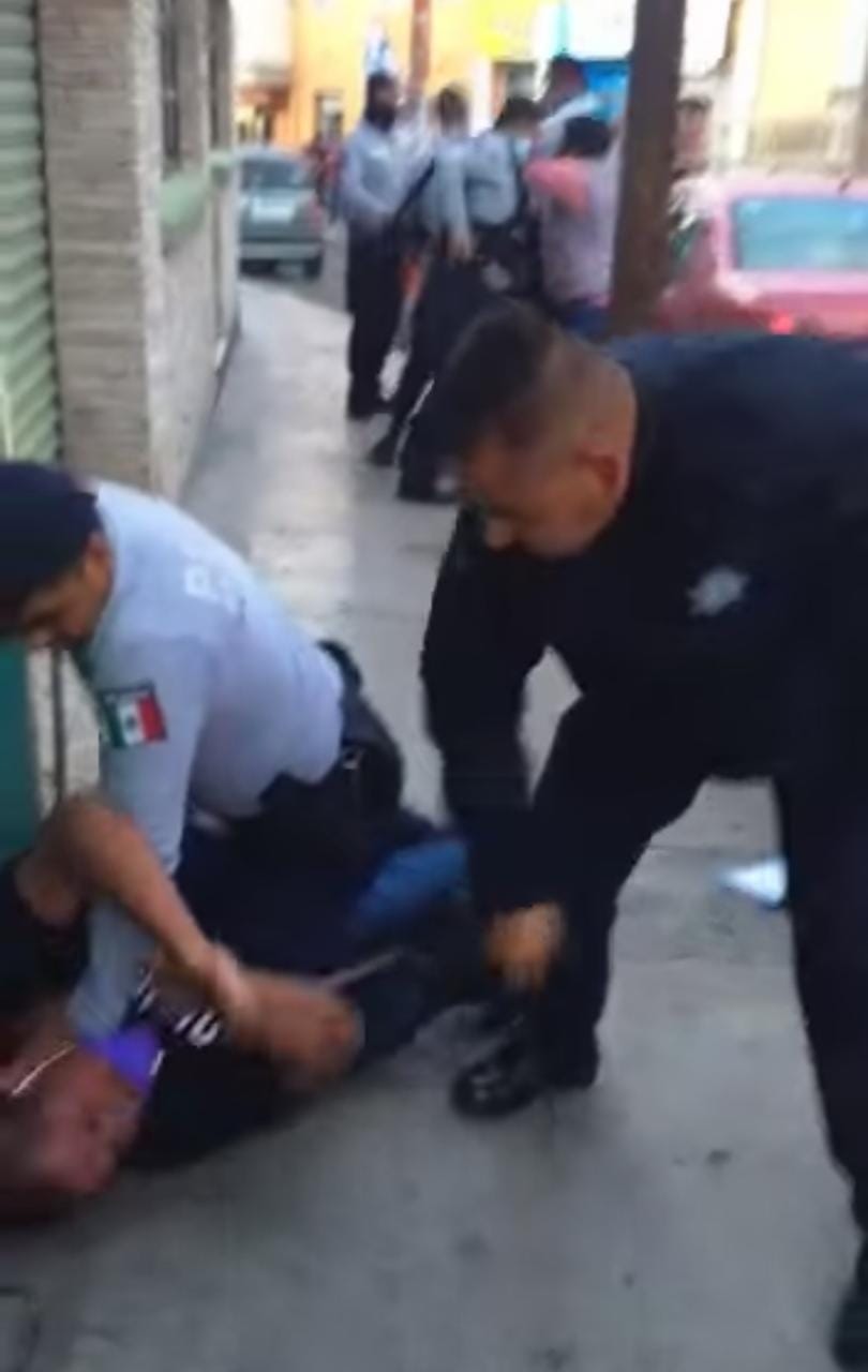 Captura del momento en que un policía saca su macana para agredir al detenido sometido en el piso. (Cortesía)