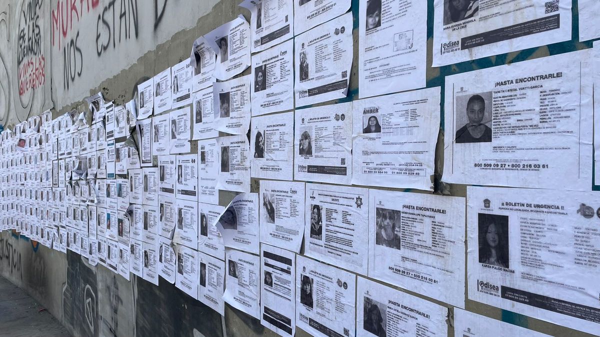 Personas pasan y detienen a observar los nombres, las edades, las fechas y lugares de desaparición. | Abadiel Martínez
