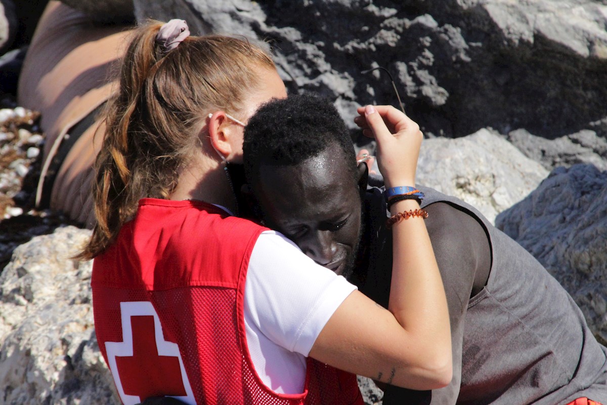 Un migrante abraza a una voluntaria de la Cruz Roja tras ser asistido en Ceuta, España. | EFE