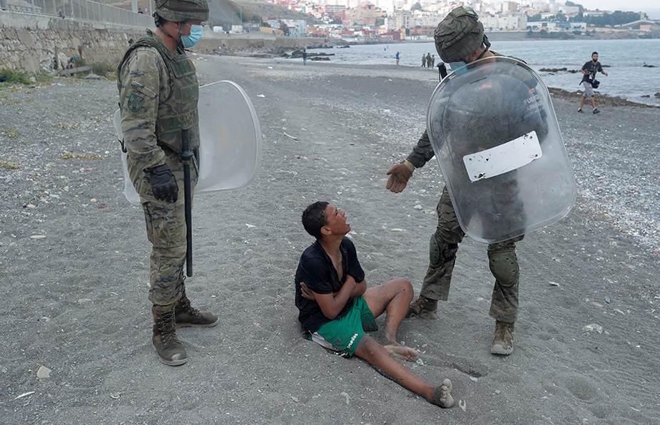 El sueño de un niño marroquí termina en la playa El Tarajal cuando soldados españoles acuden a su encuentro. | Reuters