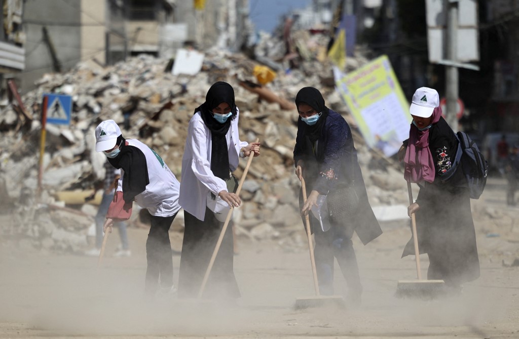 Mujeres palestinas limpian las calles de Gaza tras la destrucción por el conflicto con Israel. | AFP