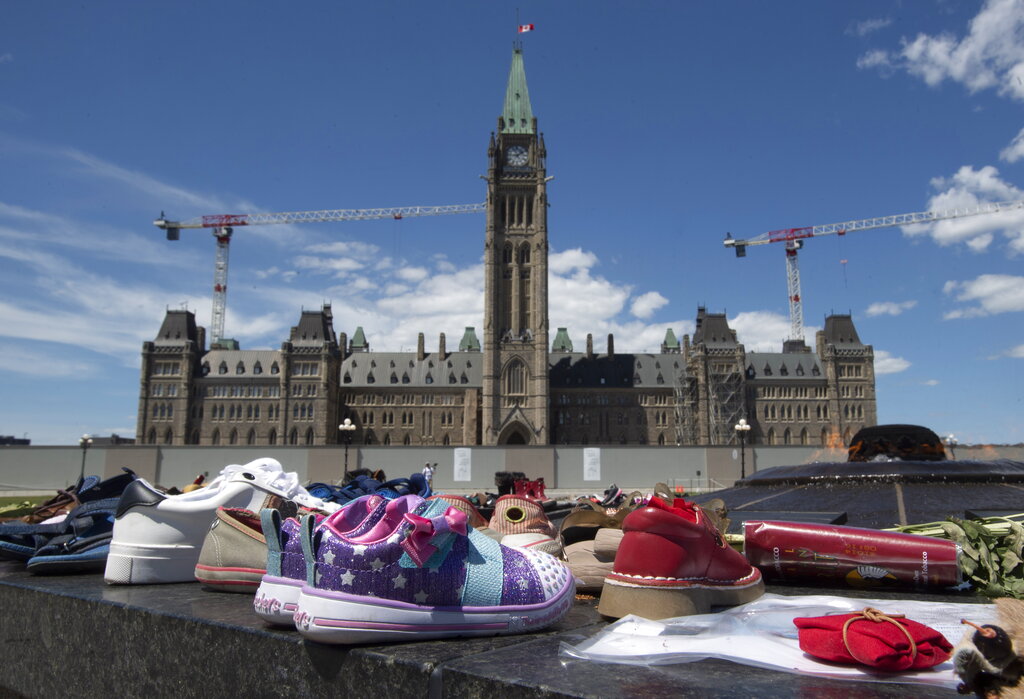 Filas de zapatos de niños fueron colocados frente al Parlamento de Canadá. (AP)