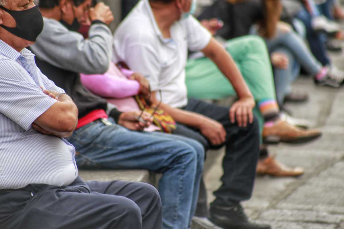 Grupo de personas espera sentada en el centro de la ciudad. (Andrés Lobato)