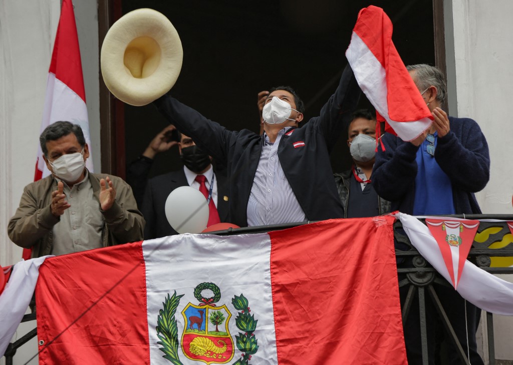 Pedro Castillo festeja avance del conteo desde el balcón de su local electoral de Peru Libre. (AFP)