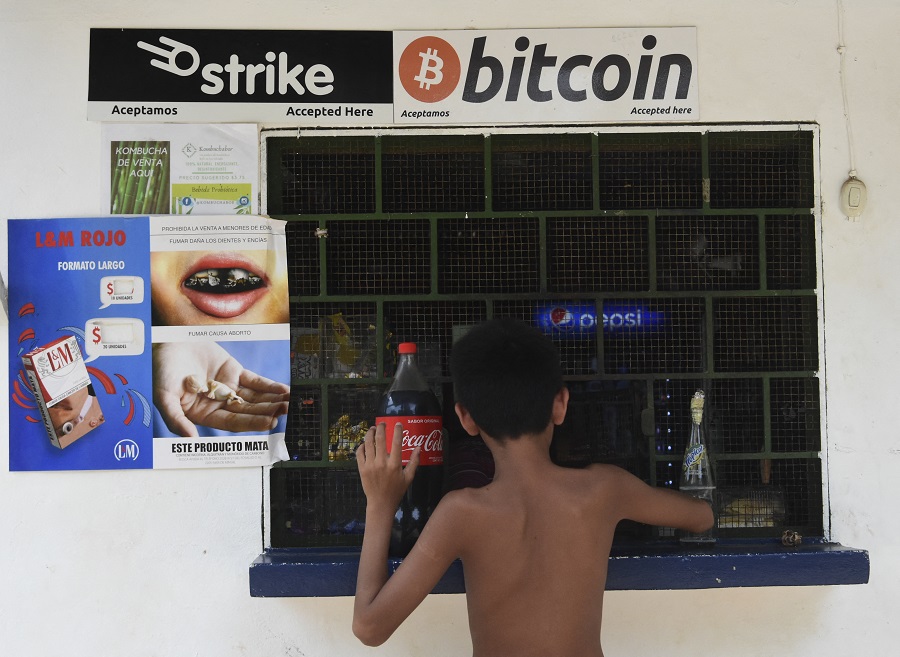 Un niño compra en una tienda que acepta bitcoins en El zonte,  a 56 km al sureste de San Salvador. (AFP)
