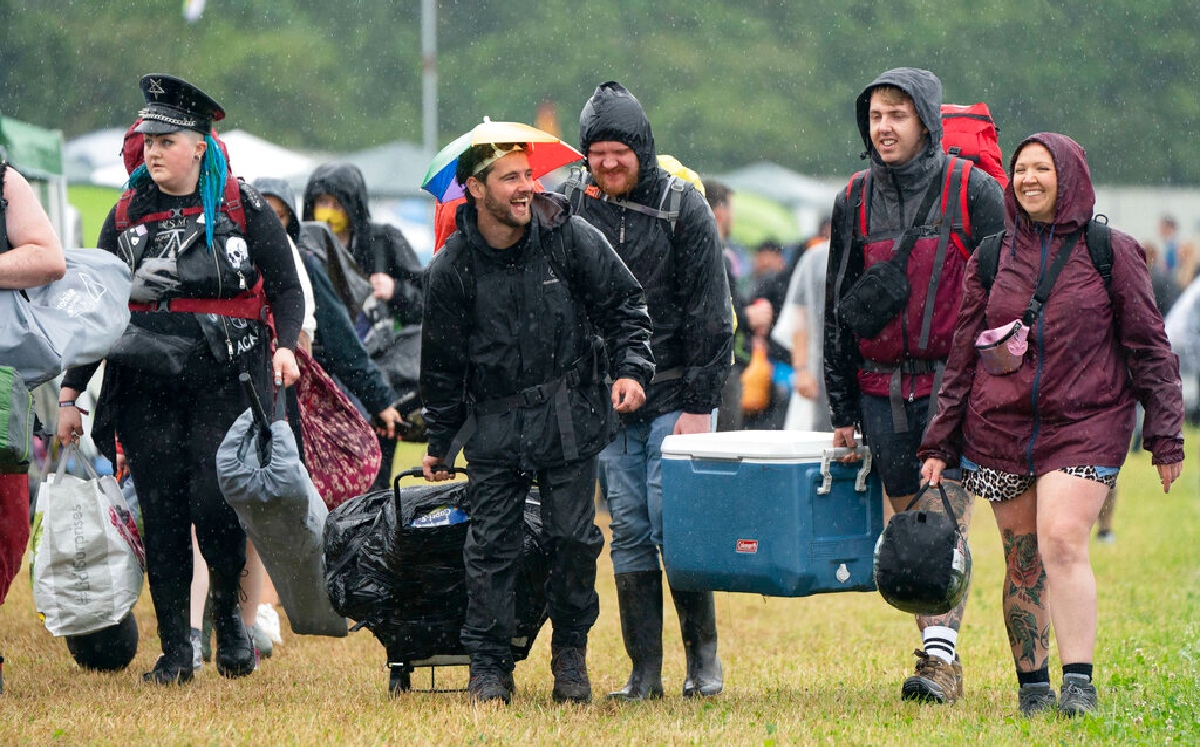 Asistentes a un festival de música llegan al recinto, bajo la lluvia, en el primer día del Download Festival. (AP)