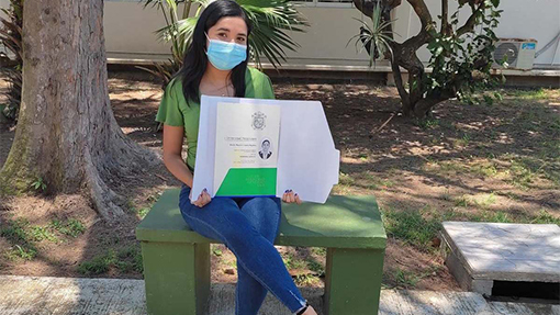 Tras titularse, joven se toma foto en la banca donde vendía dulces