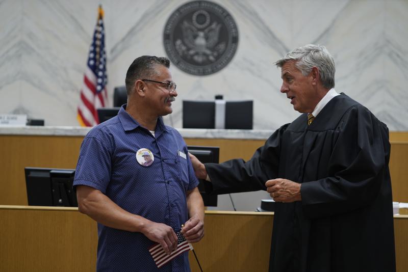 El juez Mark C. Scarsi, a la derecha, agradece a Héctor Ocegueda por su servicio militar en EU. (AP)