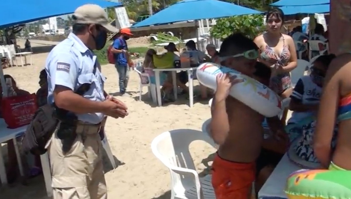 La policía ase acerca a los visitantes para invitarlos a respetar las medidas de sanidad. (Javier Trujillo)