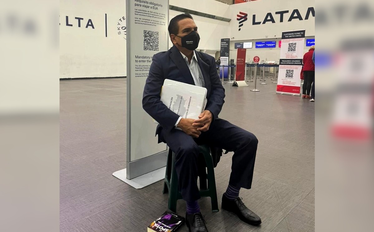 Silvano Aureoles esperó su vuelo a Estados Unidos sentado en un banco color verde. (Twitter)