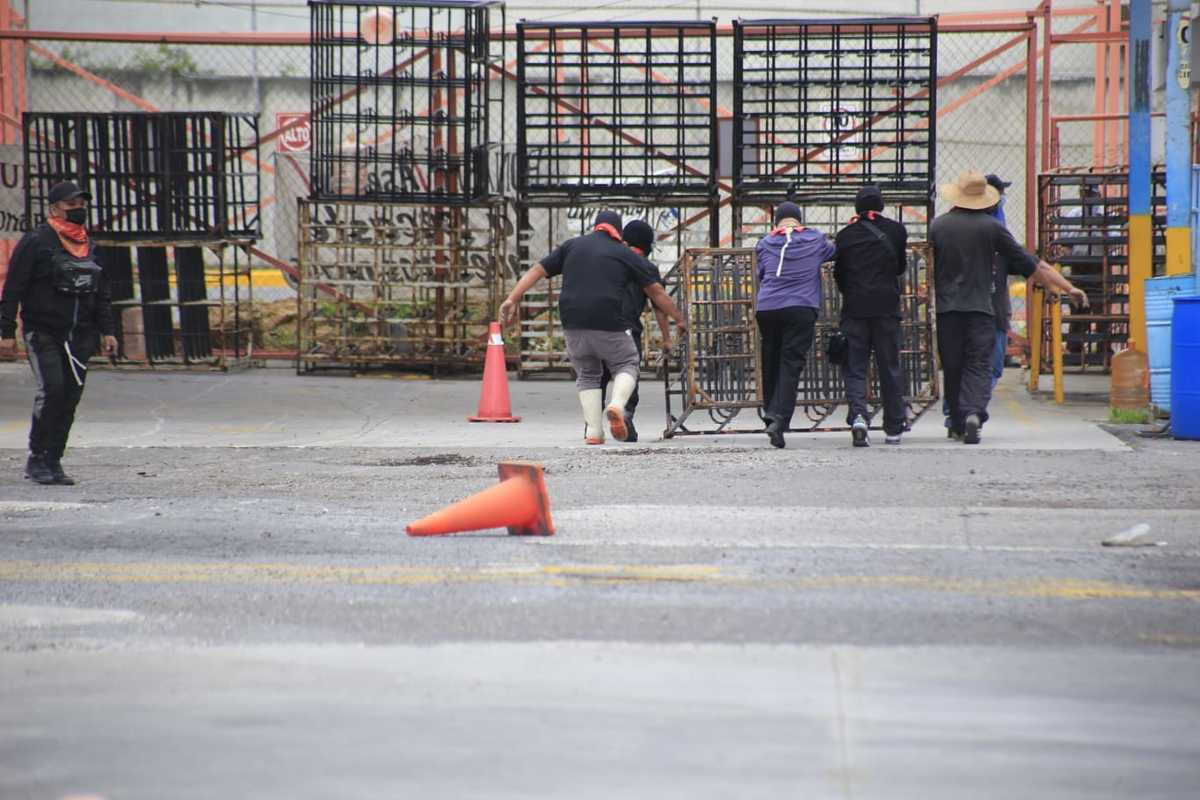 Un grupo de encapuchados arrastra parte de la infraestructura que se encuentra al interior de la planta Bonafont. (Andrés Lobato)