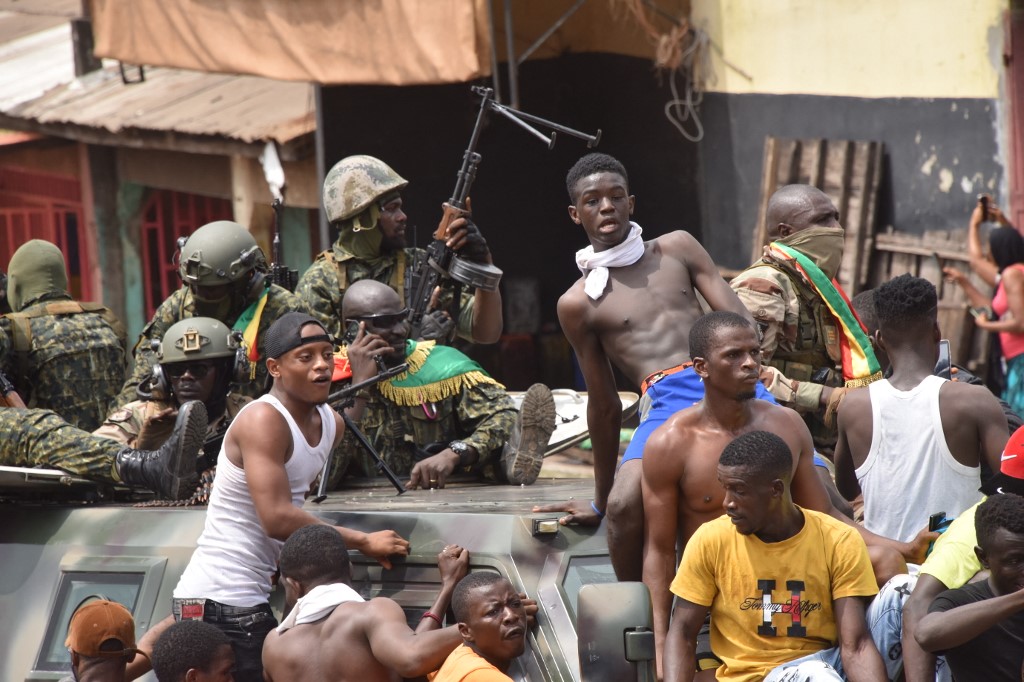Militares en Conakry, capital de Guinea, pasan entre las personas que respaldaron el golpe de Estado. | AFP