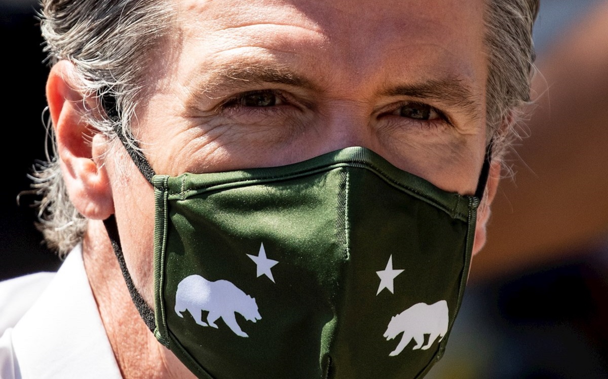 Gavin Newsom utiliza un cubrebocas estampado con el emblemático oso de California. (EFE)