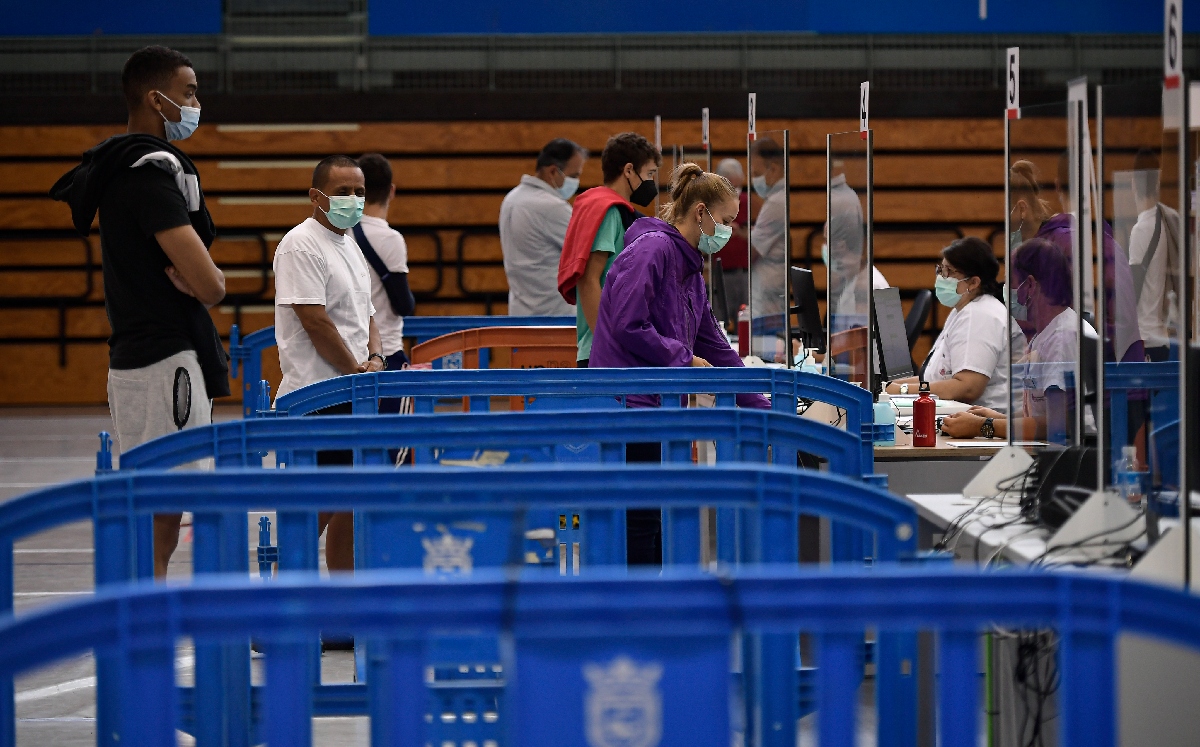 Varias personas hacen fila para recibir la vacuna de Pfizer en Pamplona, España. (AP)