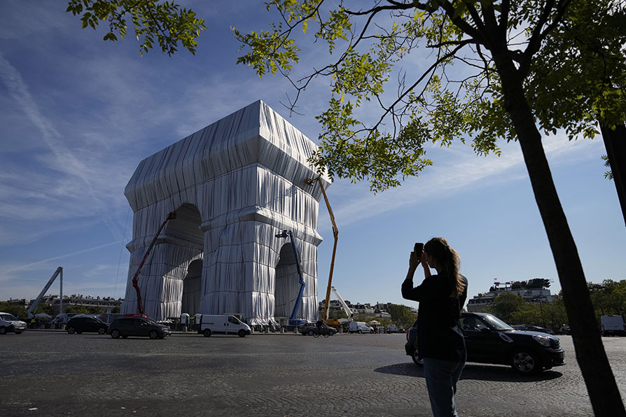 El emblemático monumento parisino fue cubierto por alrededor de 25 mil metros cuadrados de tela en azul platinado y 3 mil metros de cuerda roja. | AP