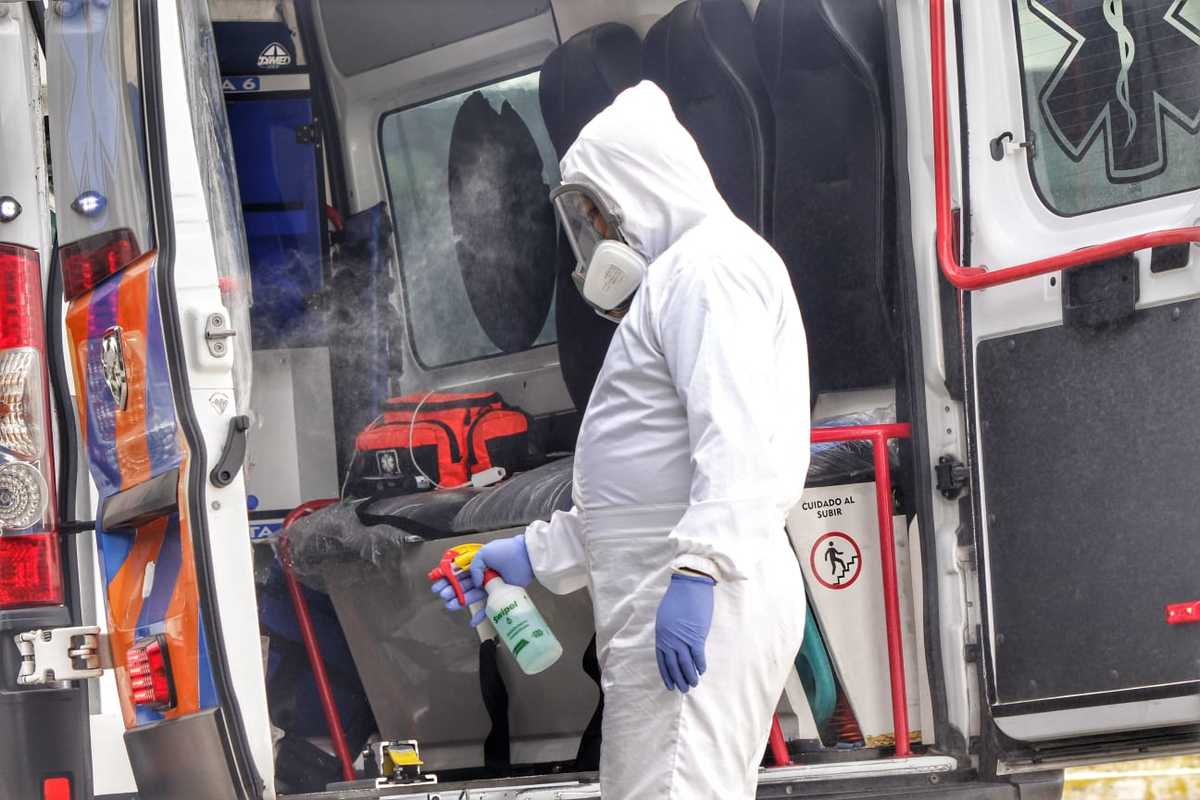 Personal de urgencias desinfecta una ambulancia tras realizar el traslado de una persona. (Melanie Torres)