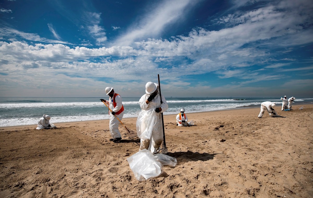 Equipo de limpieza recoge el petróleo derramado frente a la costa de Huntington Beach, California. (EFE)