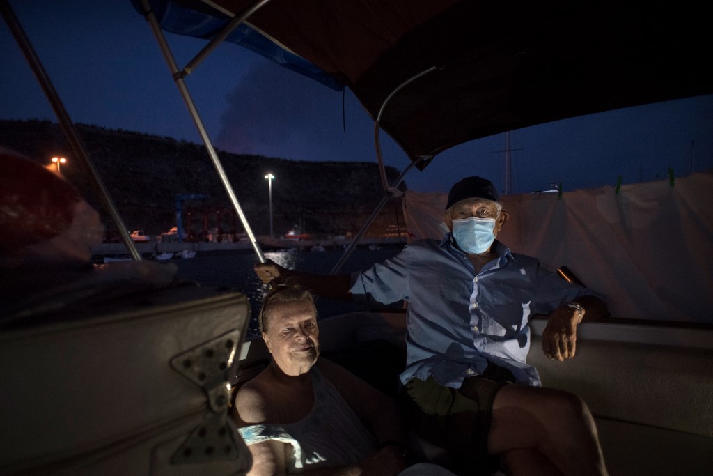 Margaretha y Luis resguardados en la lancha tras ser evacuados por la erupción del Cumbre Vieja. (AFP)