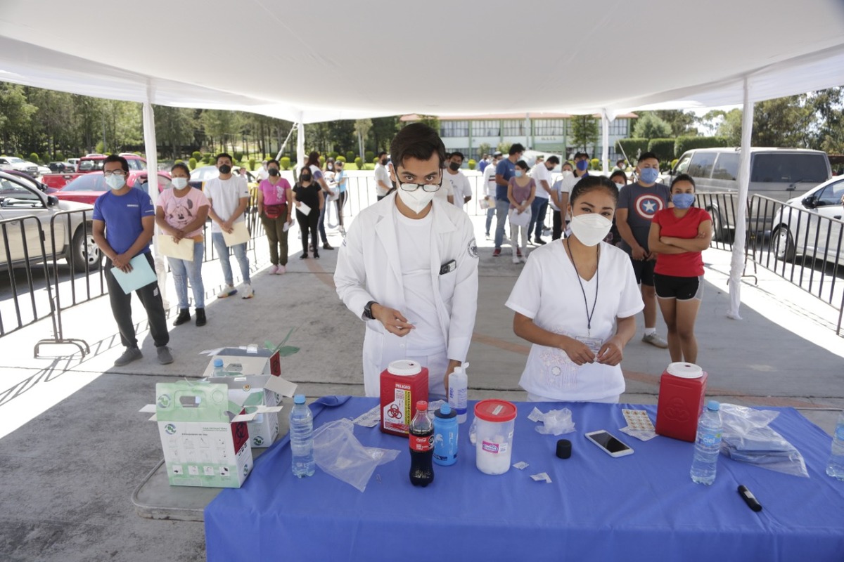 Jóvenes hacen fila para recibir el antiviral para combatir la covid-19. (Andrés Lobato)