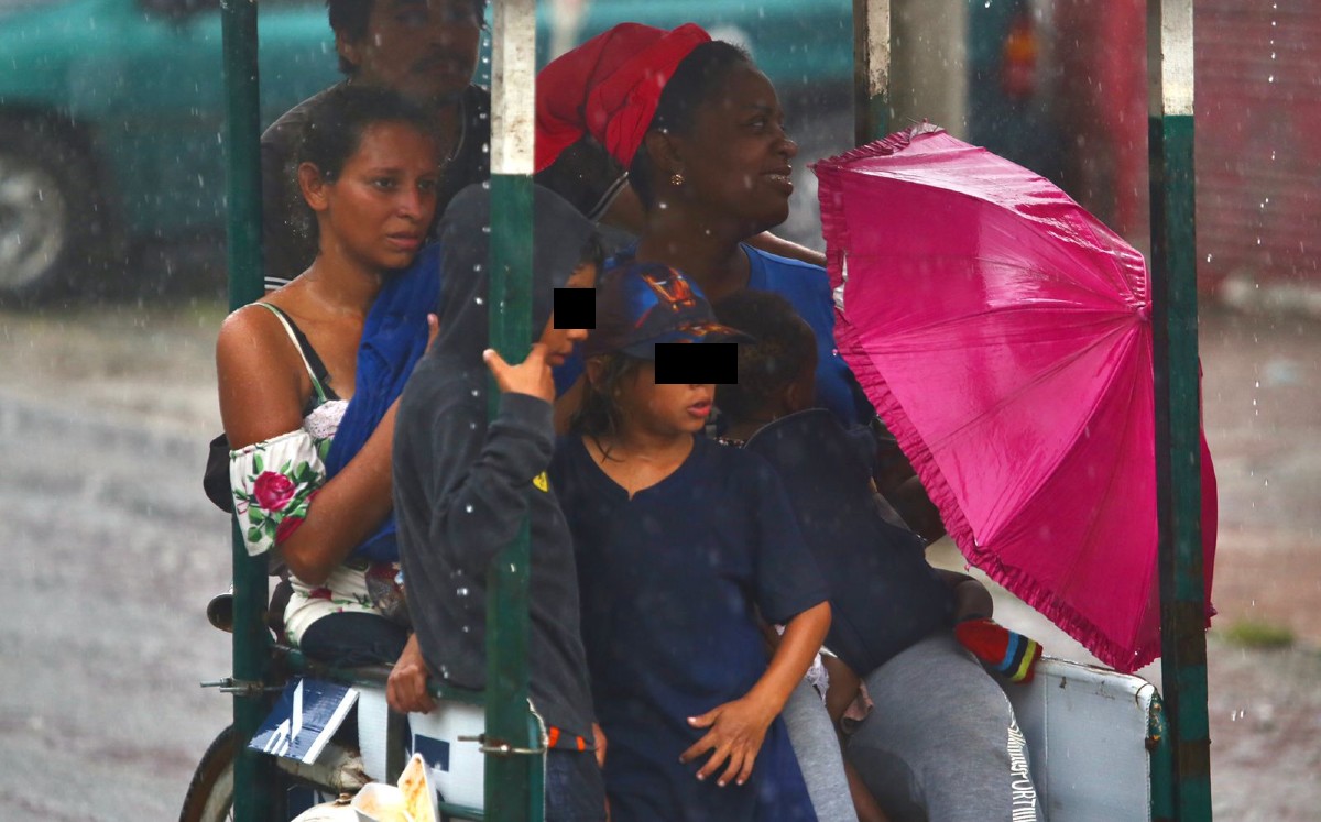 Bajo una intensa lluvia, la caravana migrante, en la que iban niños, ingresó a la cabecera municipal de Huixtl, Chiapas. | Ariel Ojeda