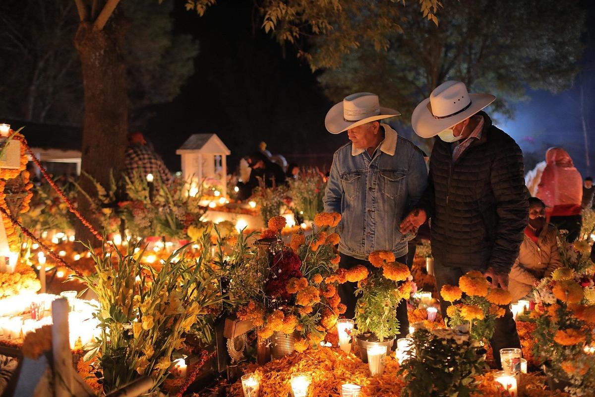 Familiares de fallecidos acuden a poner flores y velas en el panteón municipal de Tzurumutaro, Michoacán. (EFE)