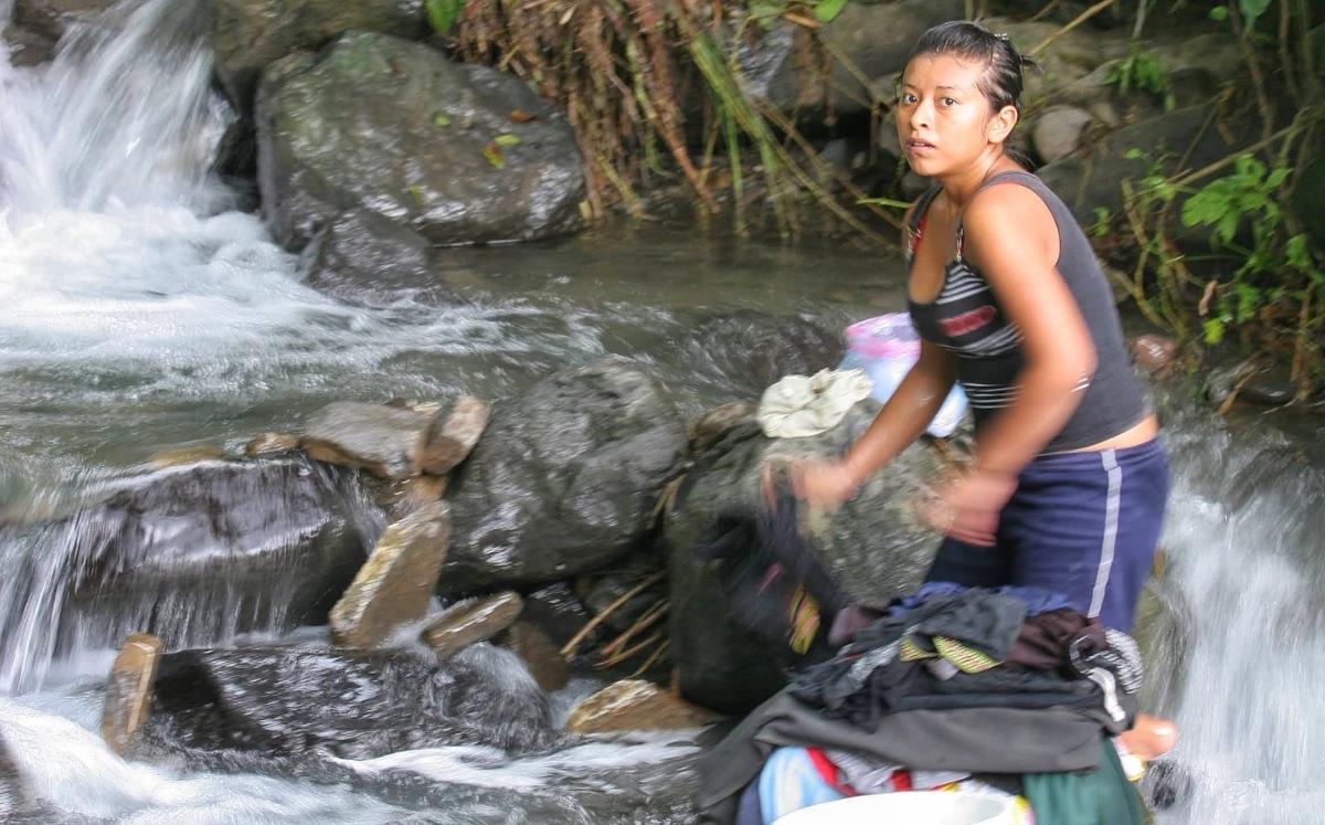 Ahuacatlán, Puebla. Una mujer lava su ropa en el río / Andrés Lobato