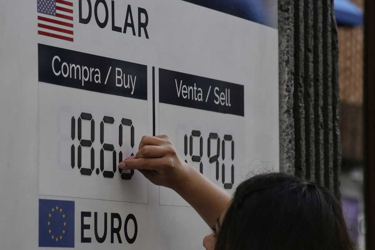En una casa de cambio, una empleada ajusta la tarifa de compra y venta del Dólar | Andrés Lobato