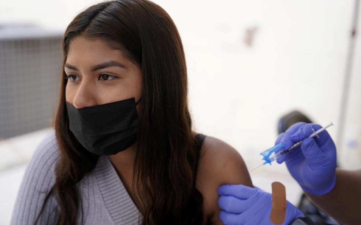 Una joven de Tijuana, México, recibe una vacuna contra el coronavirus afuera del edificio del Consulado de México. (Foto/AP)