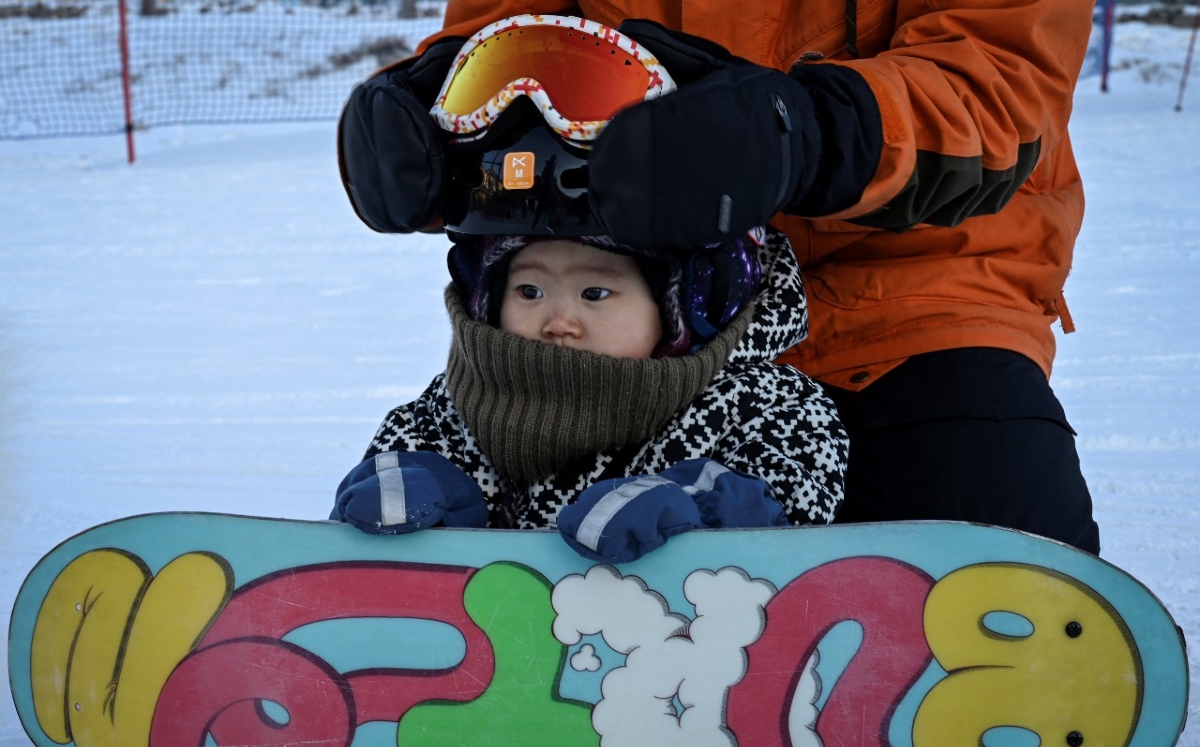Wang Yuji, bebé de 11 meses que practica snowboarding (AFP)