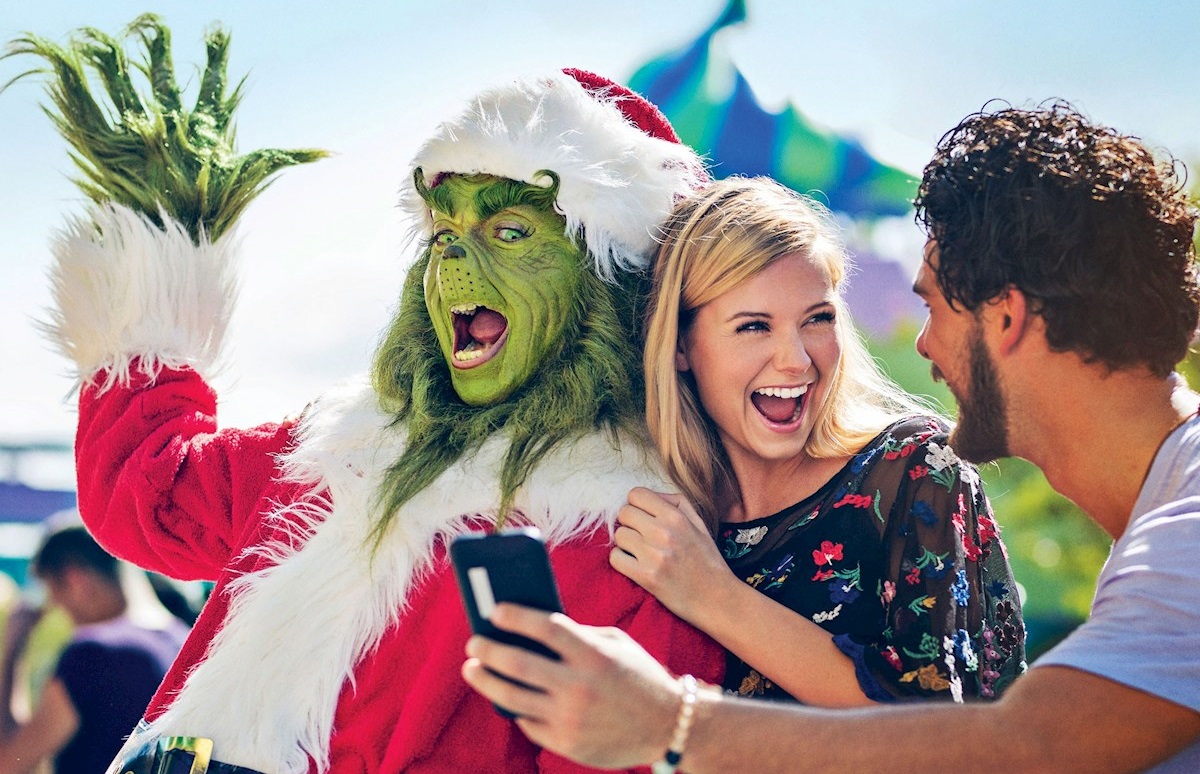 Unas personas se toman fotos con el Grinch. | Universal Studios vía EFE