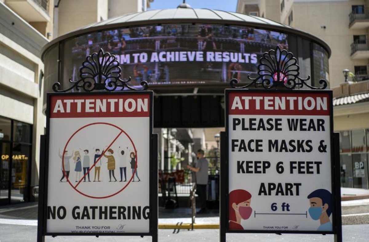 Carteles con pautas de distanciamiento social y requisitos de mascarilla en California. | AP