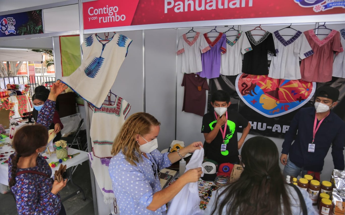 Turistas extranjeros revisan ropa artesanal que trajeron artesanas de Pahuatlán | Andrés Lobato